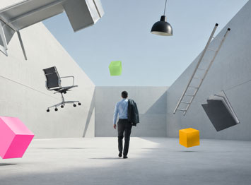Professionista di spalle in uno spazio minimalista, circondato da sedia, scala e documenti sospesi, metafora della complessità dei ruoli nelle PMI.